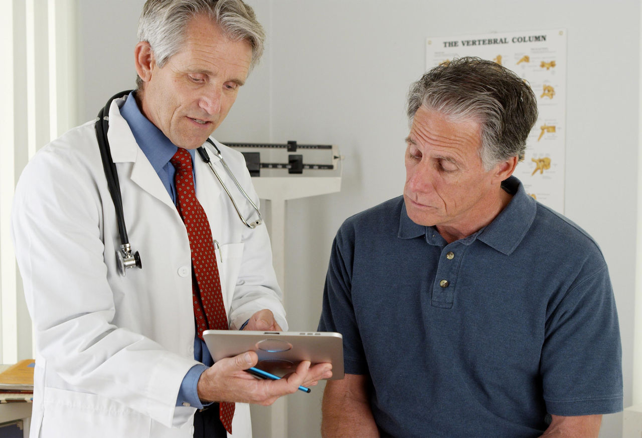 Doctor looking at iPad with patient.