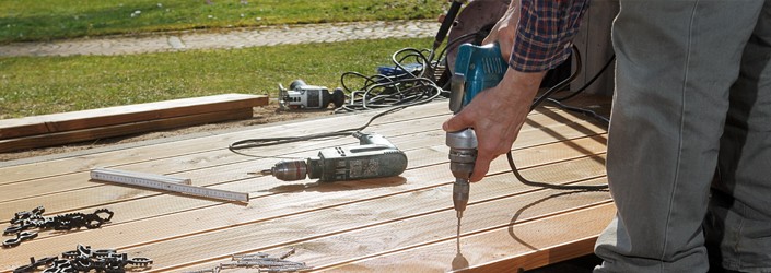 Background image showing man using a drill